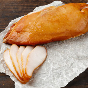Smoked-chicken-breast-on-brown-wooden-board-close-up